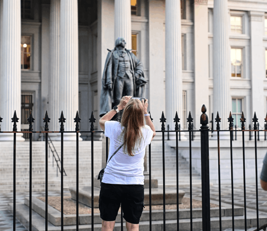 Picture of a woman on DC Tour taking a picture of a Monument