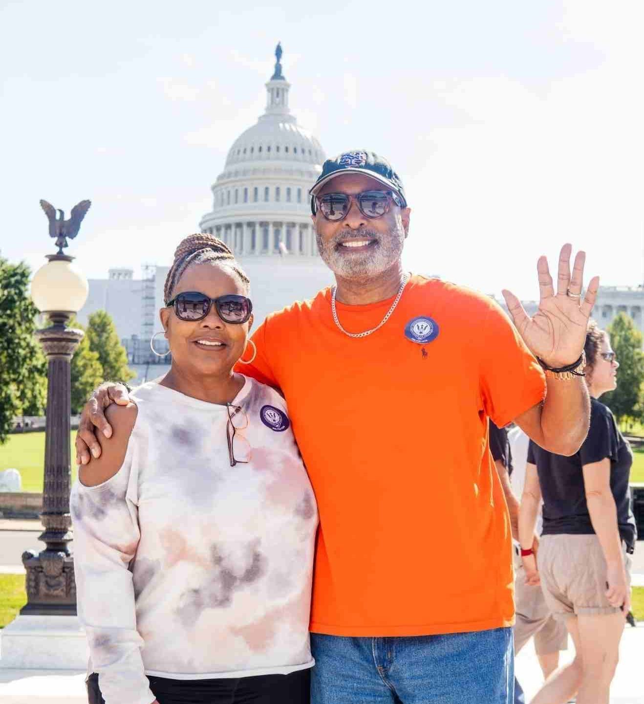 smiling couple poses in front of the U.S. Capitol Building on Washington DC tour